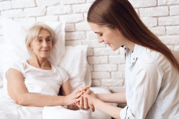 Ragazza Che Prende Cura Donna Anziana Letto Casa Tengono Mano — Foto Stock