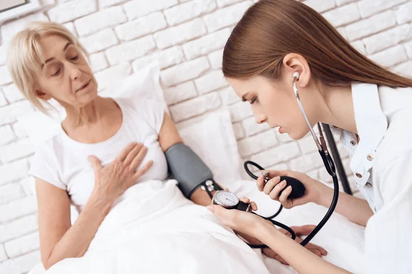 Niña Amamantando Una Anciana Usando Tonómetro Para Medir Presión Arterial —  Fotos de Stock