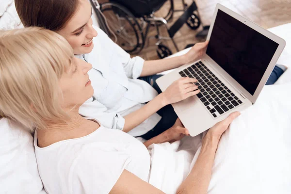 Chica Que Cuida Mujer Anciana Cama Uso Ordenador Portátil — Foto de Stock