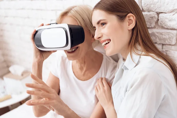 Girl nursing elderly woman at home and they using virtual reality