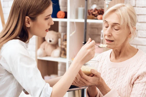 Flicka Omvårdnad Äldre Kvinna Rullstol Och Hjälpande Pensionär Med Middag — Stockfoto