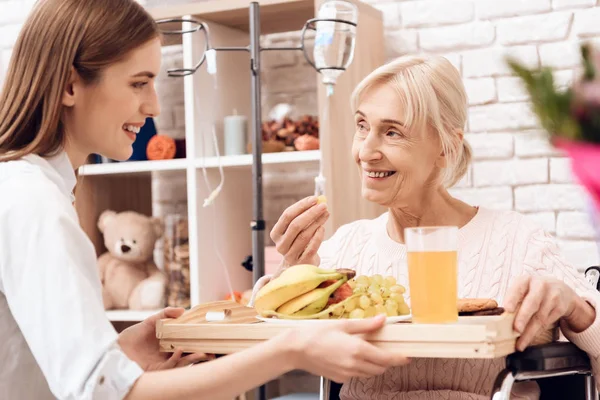 Flicka Vårdar Äldre Kvinna Rullstol Och Föra Frukost Bricka — Stockfoto