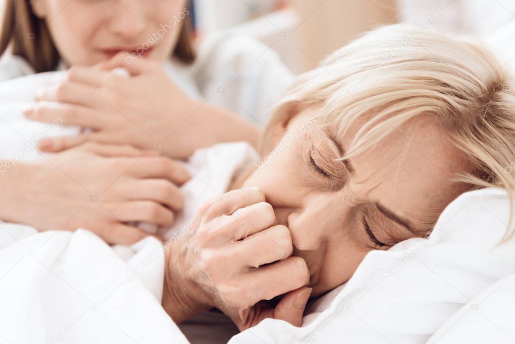 Close up of elderly woman feeling bad and girl caring for her