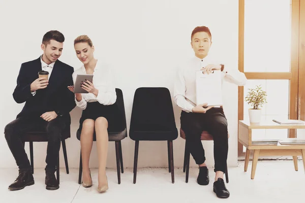 HR director woman in blouse and skirt sitting with coworkers and showing tablet to man