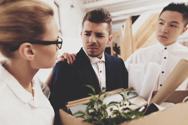 HR director woman in blouse and skirt and coworker standing near fired man