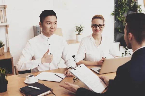 HR director woman in blouse and skirt discussing resume with men at job interview