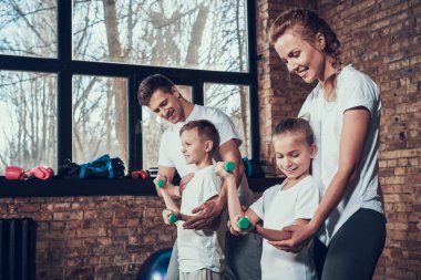 Babam ve annem dumbbells ile egzersiz yaparak çocuklara yardım