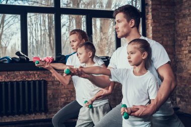 Babam ve annem dumbbells ile egzersiz yaparak çocuklara yardım