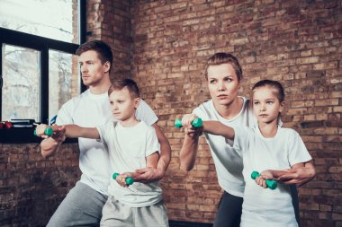 Babam ve annem dumbbells ile egzersiz yaparak çocuklara yardım