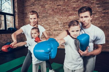 Baba ve anne çocuk spor salonunda boks eğitimi