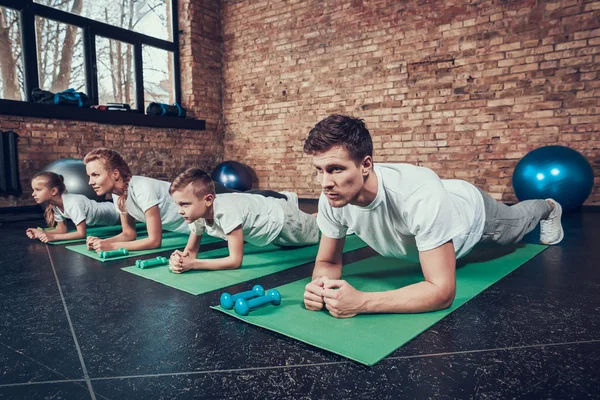 Baba, anne, kızı ve oğlu tahta spor salonunda yapıyor
