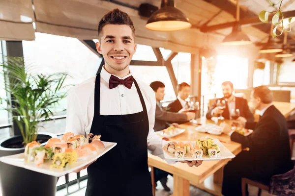 Suşi restoranında Çin işadamları ile toplantı ile poz garson