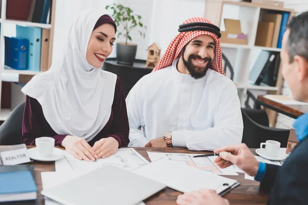 Realtor telling about terms of purchase and sale agreement for young Arab couple
