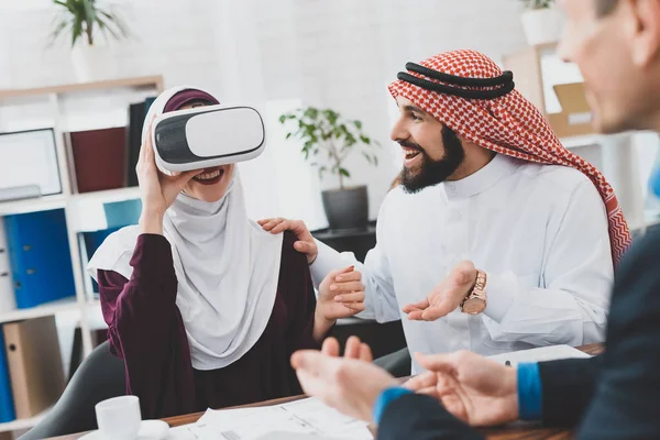 Arab woman in hijab studying house in virtual reality glasses