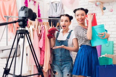 Renkli çanta ve kamera için kırmızı ayakkabılar sunan iki moda blogger kız