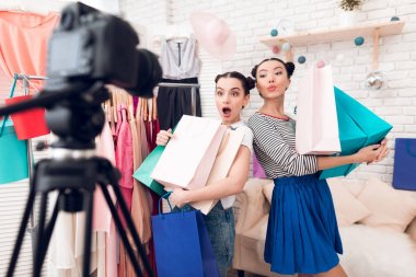 İki moda blogger kız kamera renkli çanta ile poz