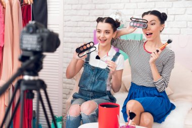 Kamera için renkli göz gölgeler sunan iki moda blogger kız