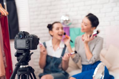 Kamera için farklı fırçalar sunan iki moda blogger kız