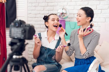 Kamera için farklı fırçalar sunan iki moda blogger kız