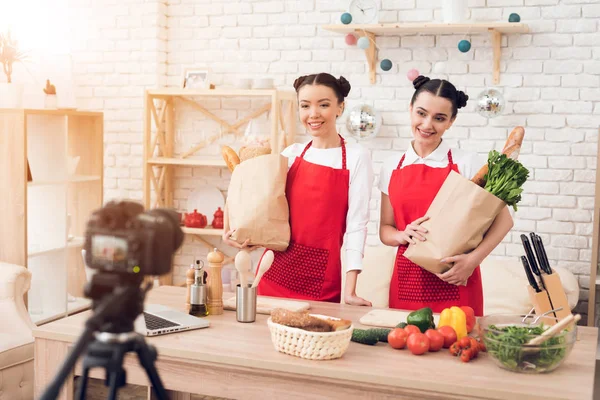 Dvě Kulinářské Bloggerů Červených Zástěry Drží Balíčky Jídlem Kameru — Stock fotografie