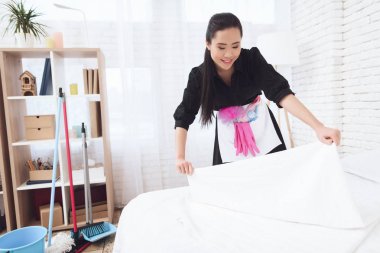 Genç Asyalı hizmetçi evde yatak değiştirme