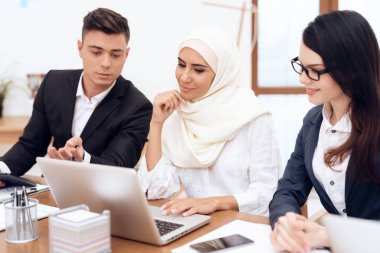 Birlikte meslektaşları ile ofiste çalışan Türban Arap kadın