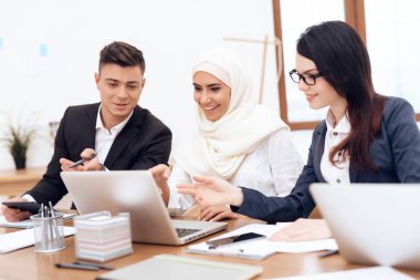 Birlikte meslektaşları ile ofiste çalışan Türban Arap kadın