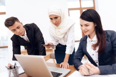 Birlikte meslektaşları ile ofiste çalışan Türban Arap kadın