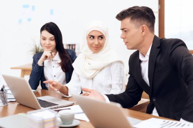 Birlikte meslektaşları ile ofiste çalışan Türban Arap kadın