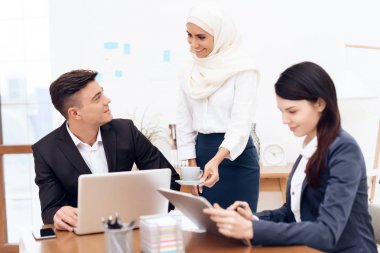 Birlikte meslektaşları ile ofiste çalışan Türban Arap kadın