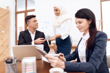 Birlikte meslektaşları ile ofiste çalışan Türban Arap kadın