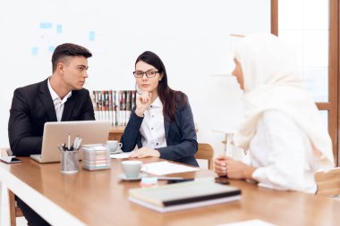 Birlikte meslektaşları ile ofiste çalışan Türban Arap kadın