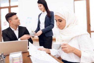 Birlikte meslektaşları ile ofiste çalışan Türban Arap kadın