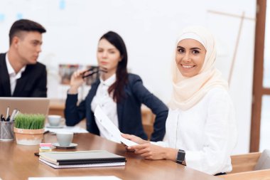 Birlikte meslektaşları ile ofiste çalışan Türban Arap kadın