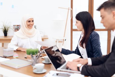 Birlikte meslektaşları ile ofiste çalışan Türban Arap kadın