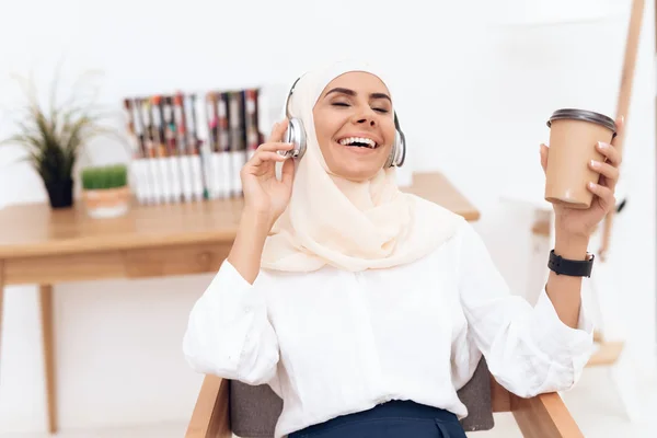 阿拉伯妇女在头巾听音乐在耳机 — 图库照片