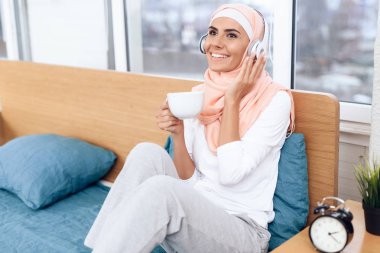Çay içme ve yatakta otururken müzik Arap kadın