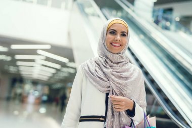 Arap kadın alışveriş merkezi alışveriş torbaları ile yürüyüş 