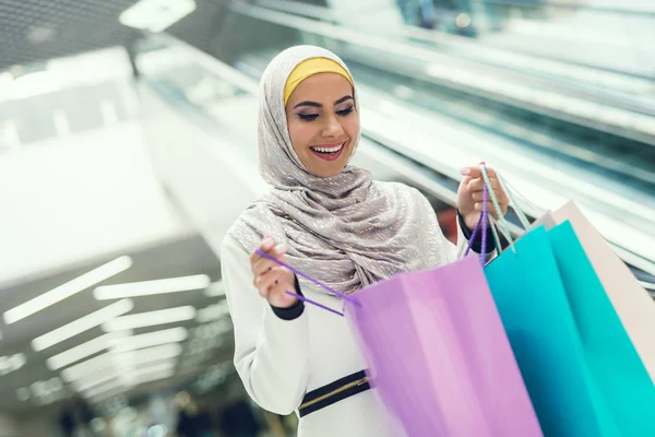 Arab woman walking in shopping mall with shopping bags