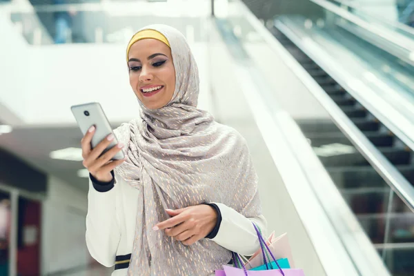 Araberin Läuft Mit Einkaufstüten Einkaufszentrum Und Nutzt Smartphone — Stockfoto