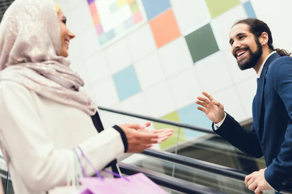 Arab man meeting woman during shopping in mall