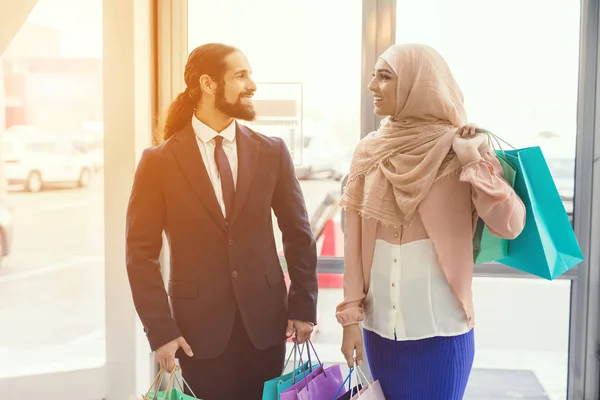 Arab man and woman walking at shopping mall