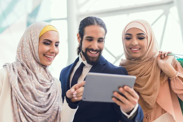 Arab women and man in shopping mall using tablet pc