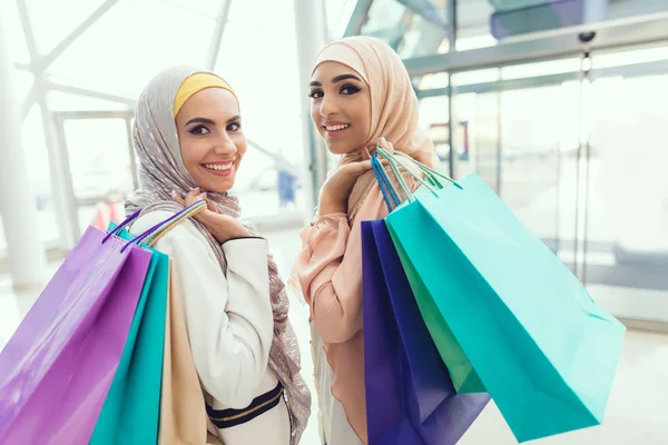 Arab women walking in mall with shopping bags