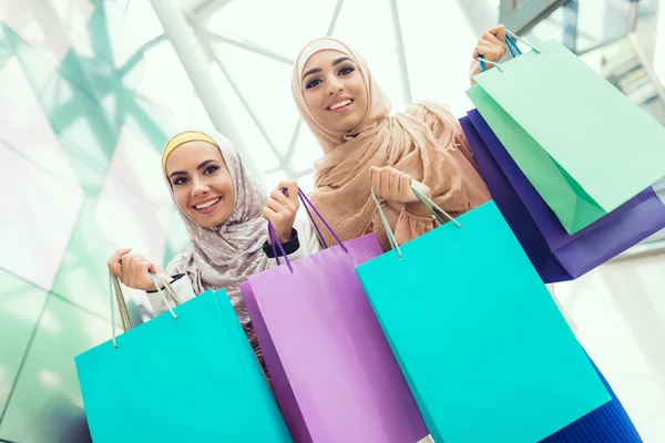 Arab women holding shopping bags in mall