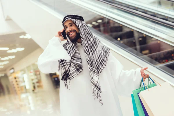 Arabische Man Met Boodschappentassen Praten Smartphone Winkelcentrum — Stockfoto