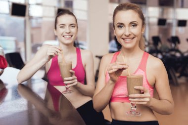 Anne ve kızı spor salonunda protein karışımlarından içme spor giyim