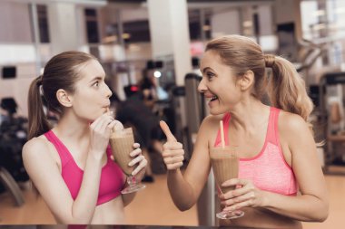 Anne ve kızı spor salonunda smoothies içme spor giyim