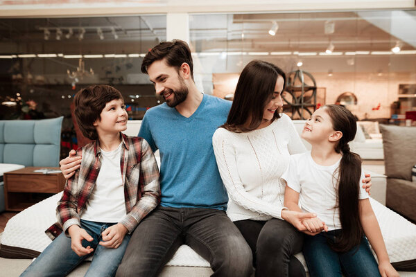 family choosing soft mattress in orthopedic furniture store