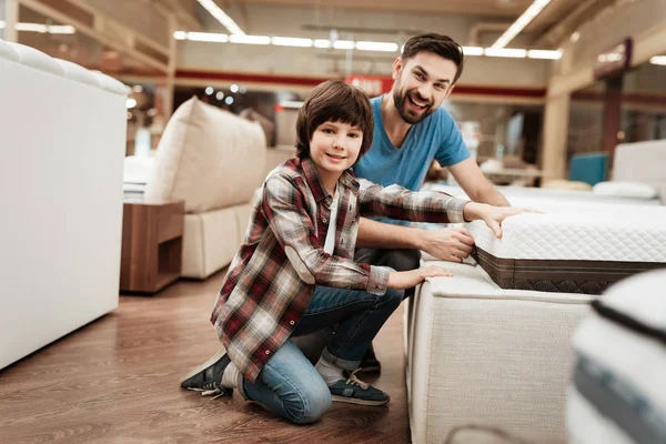 父亲与儿子在家具店选择矫形床垫 — 图库照片